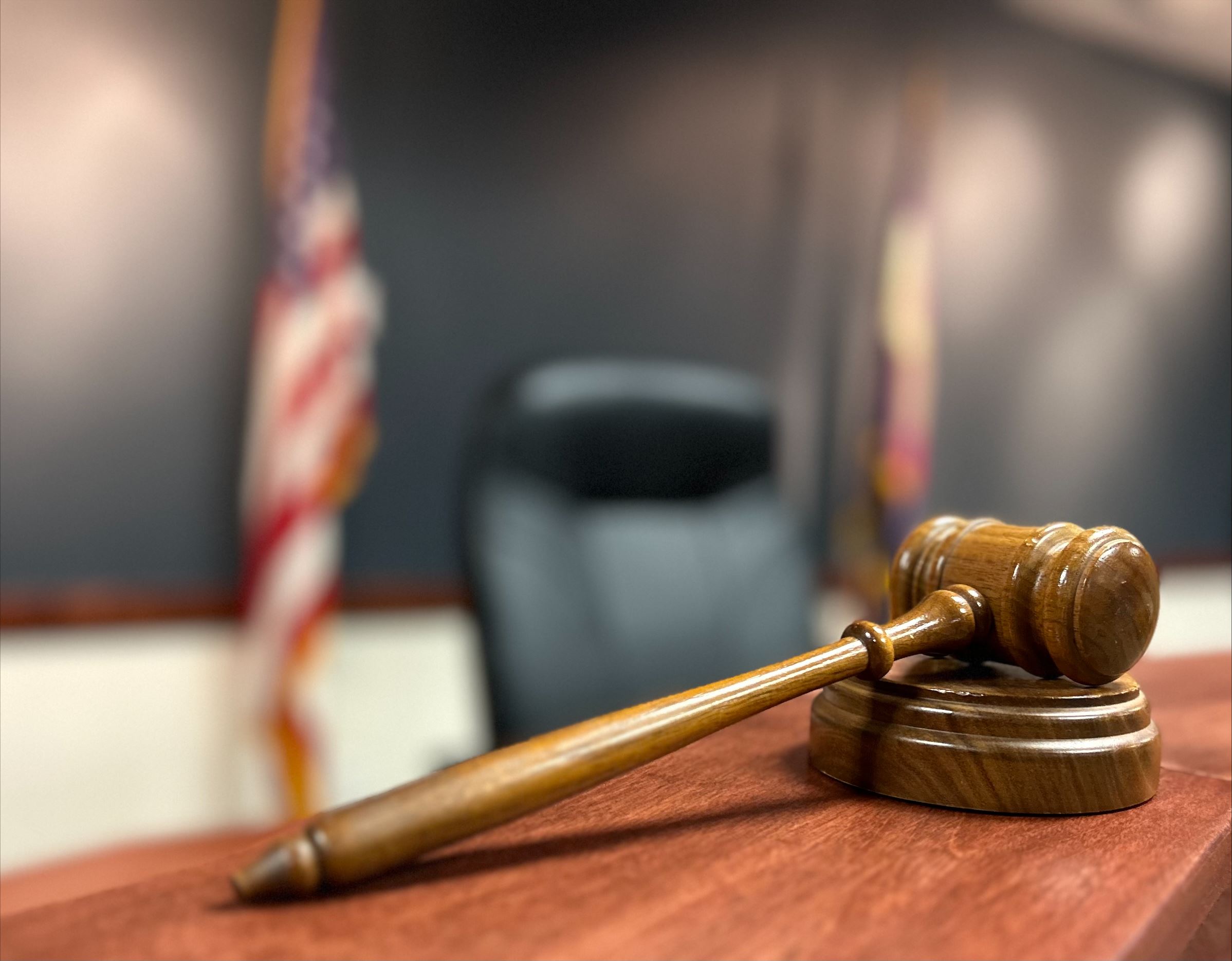 Gavel and block on dais with United States and Colorado Flag in background