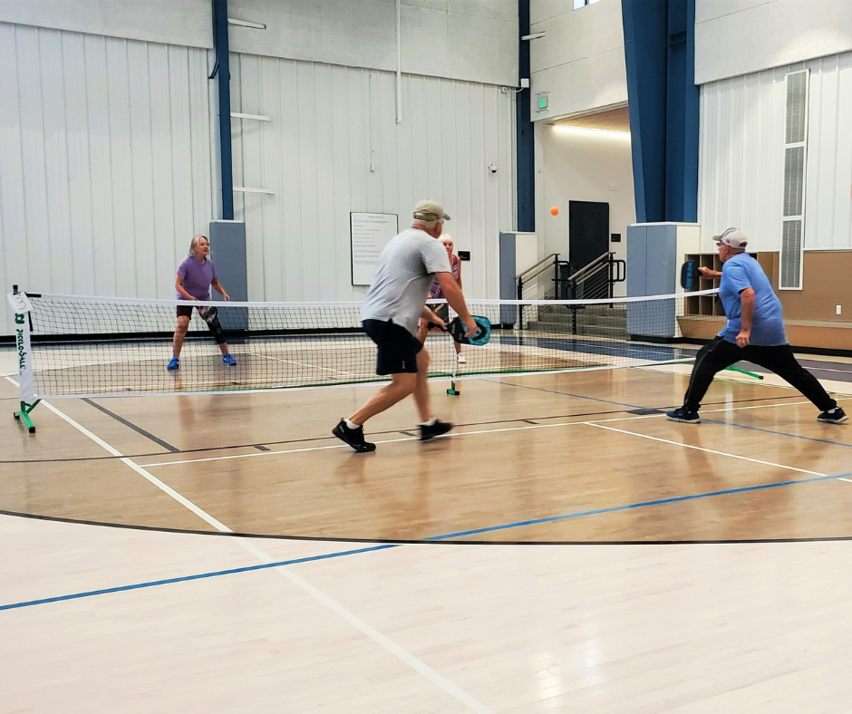 Photo of active adults playing indoor pickleball