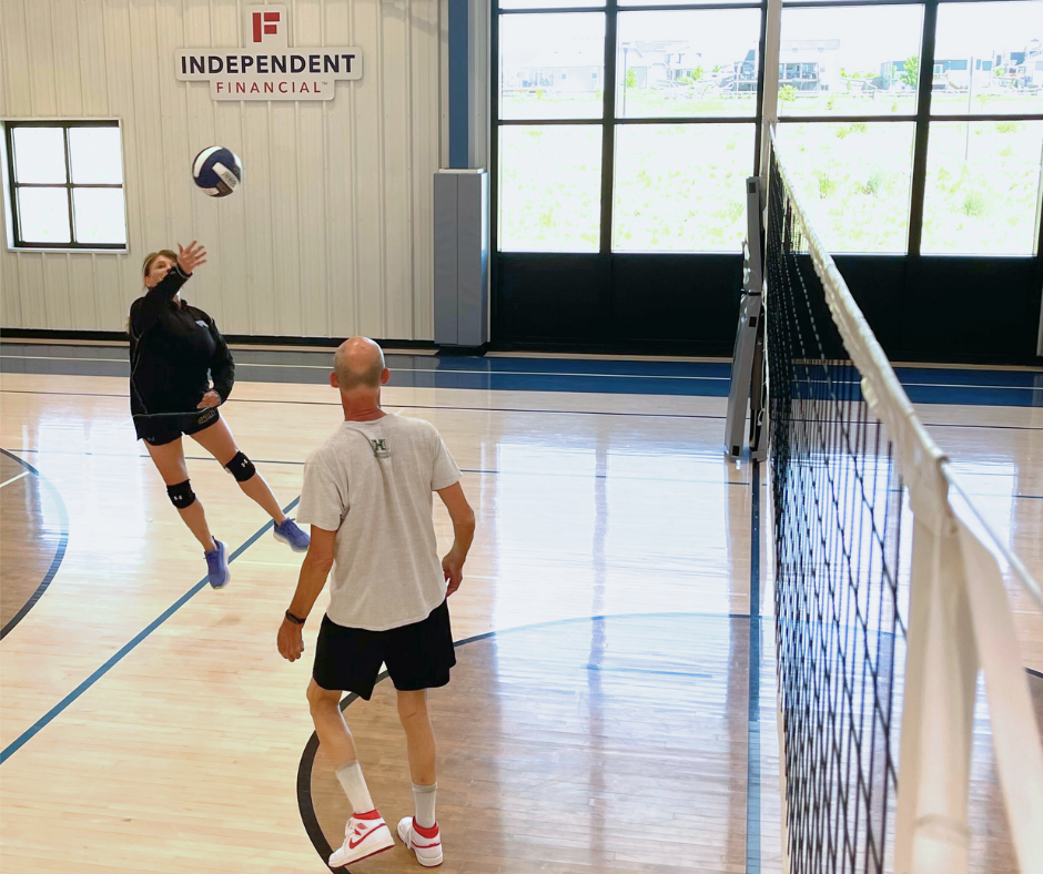 Photo of active adults playing indoor volleyball
