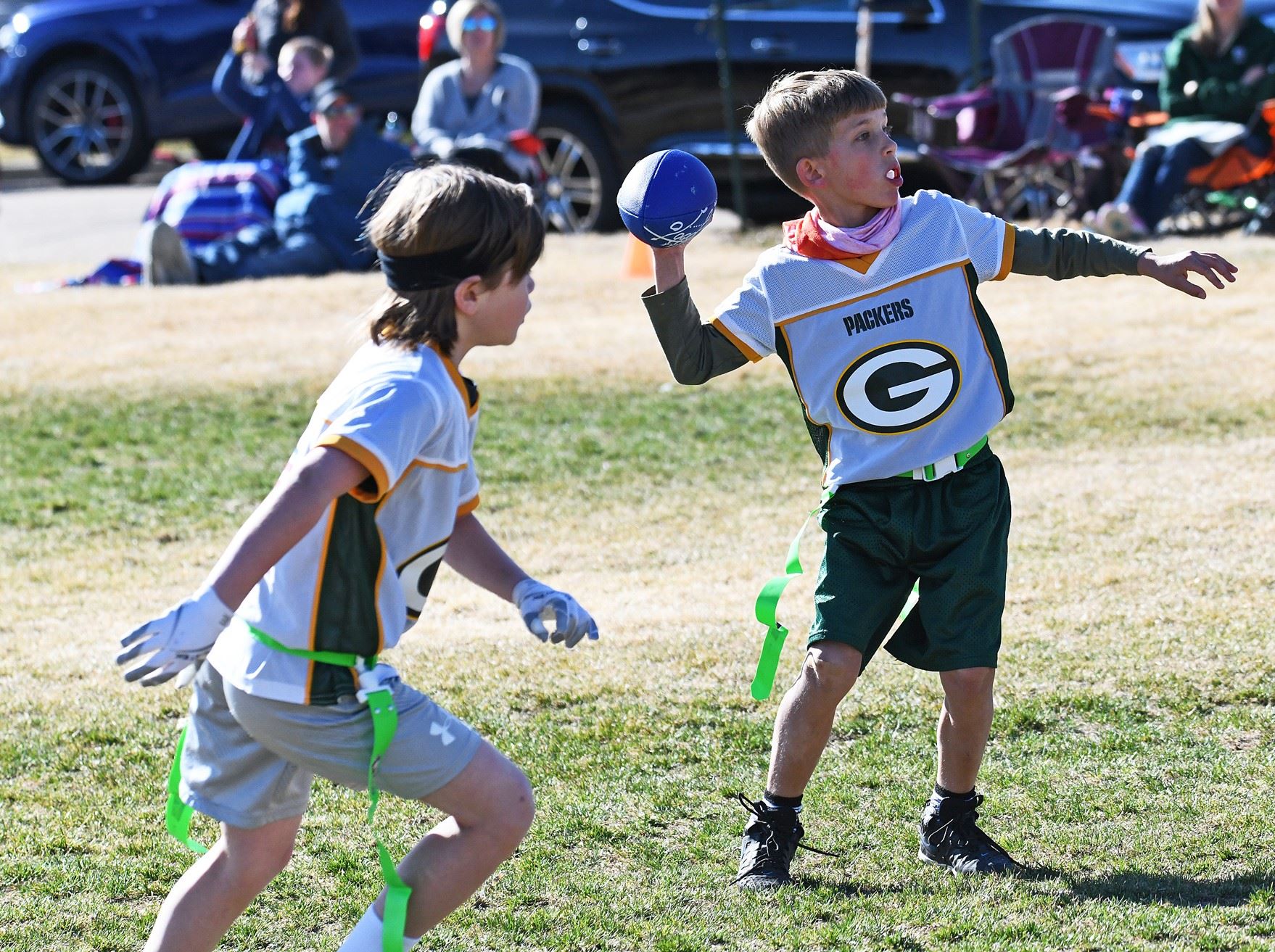 Photo of a young boy throwing with a football
