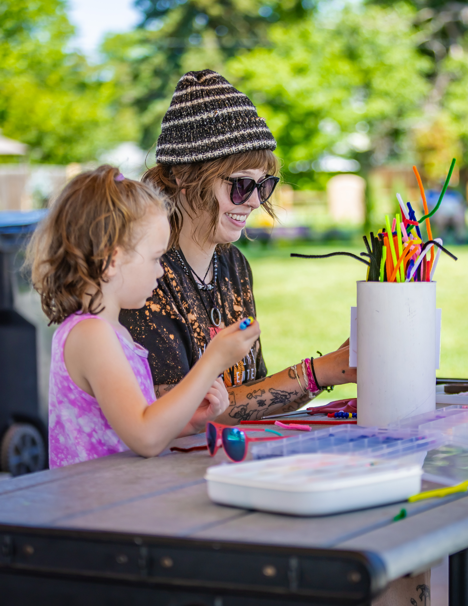 Child enjoying free crafts at the Wildfire Arts Center booth during Art in the Park at the Berthoud.