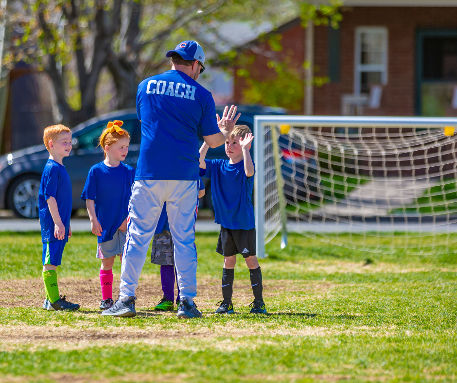 Soccer coah giving a high five to a player